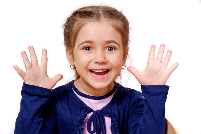 Young girl smiling with hands raised