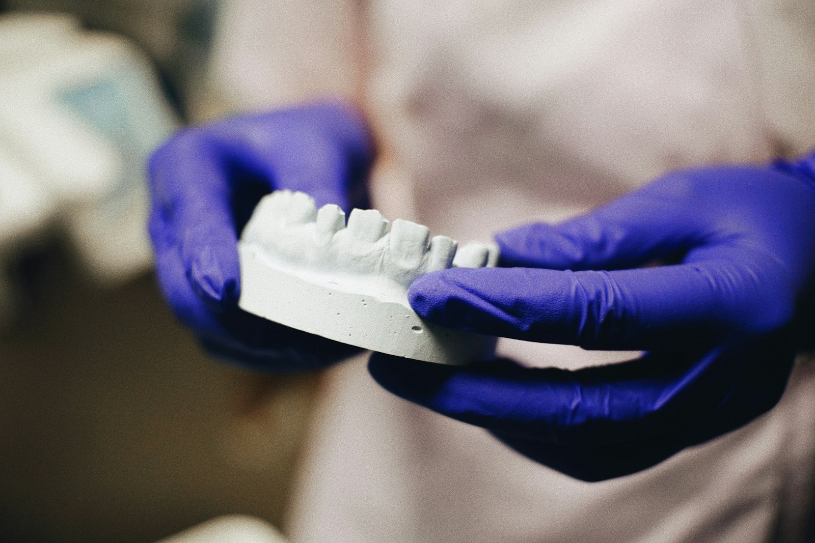 A close up of a person wearing blue gloves holding a toothbrush A close up of a person wearing blue gloves holding a toothbrush