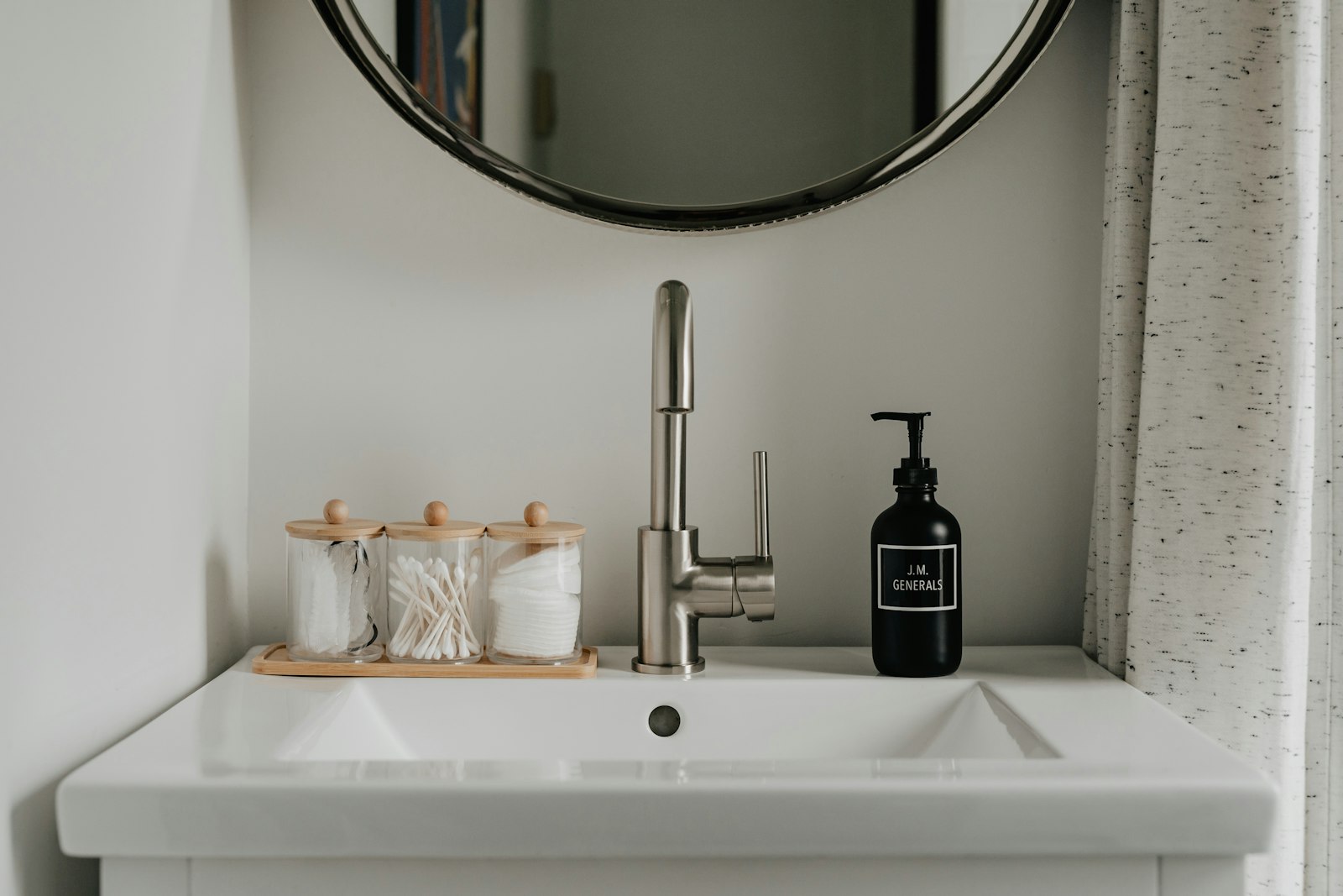 A bathroom sink with a soap dispenser next to it A bathroom sink with a soap dispenser next to it