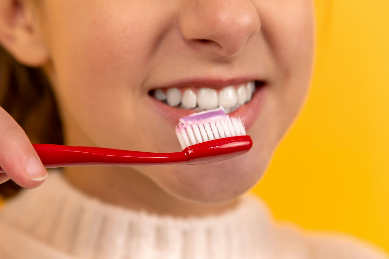 Girl with red and white toothbrush in mouth Girl with red and white toothbrush in mouth