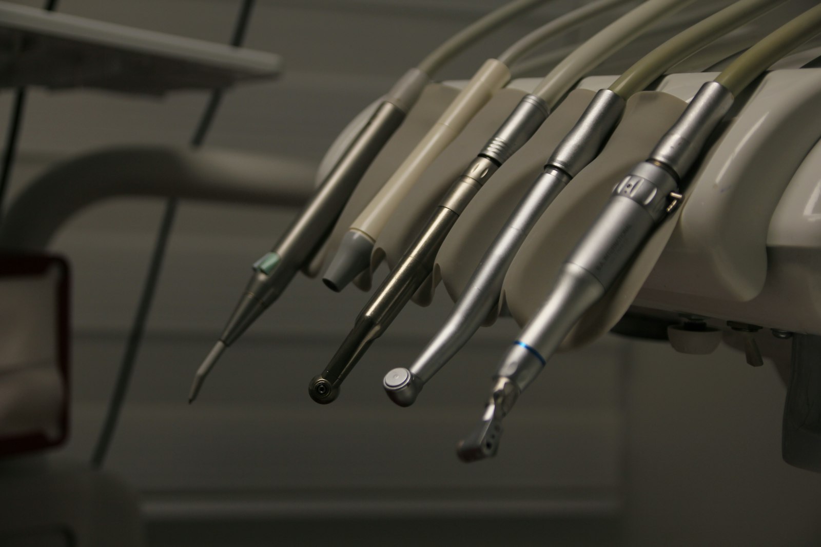 A row of dental instruments hanging from a wall